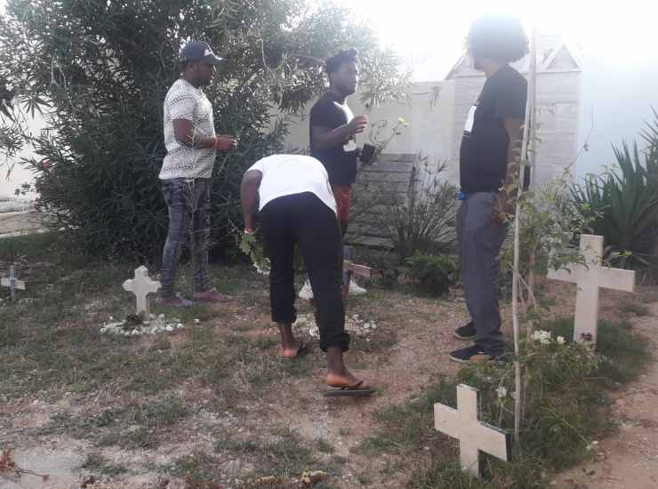Migranti superstiti naufragio 2013 al cimitero di Lampedusa
