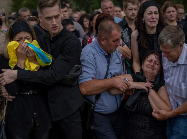 Anastasia Ohrimenko, 26 anni (sx), piange ai funerali di suo marito Yury Styglyuk, un soldato ucraino morto in combattimento il 24 agosto a Maryinka, Donetsk. Le esequie sono state celebrate a Bucha il 31 agosto 2022.