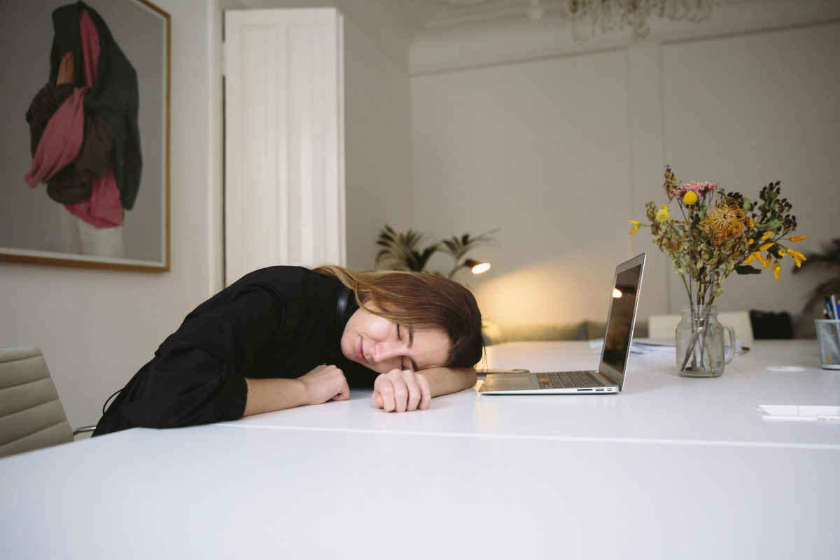 Ragazza che dorme appoggiata su di un tavolo